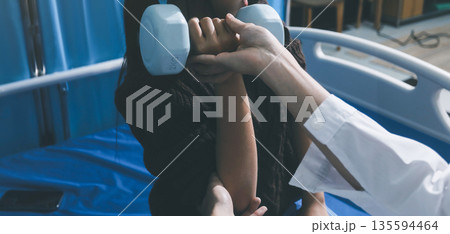 Unrecognizable uses blue hand weight during physical therapy session 135594464