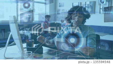 Gesturing African American male interacting with laptop and digital overlays in modern office Gesturing African American male interacting with laptop and digital overlays in modern office 135594548