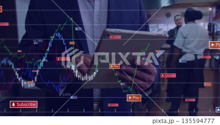 Asian man in navy blazer holding tablet analyzing charts in cafe, with Play Subscribe Like icons Asian man in navy blazer holding tablet analyzing charts in cafe, with Play Subscribe Like icons 135594777