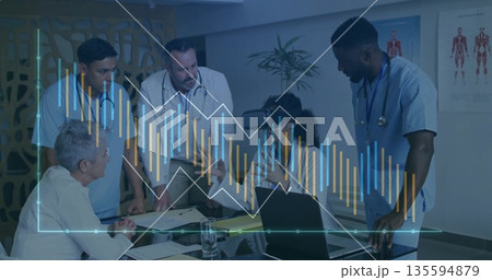Collaborating medical staff wearing lab coats and VR headset around conference table, with laptop Collaborating medical staff wearing lab coats and VR headset around conference table, with laptop 135594879