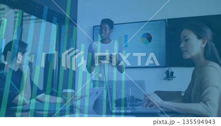 Leading business speaker showing data graphs in conference room, with tablet, laptops, pie chart 135594943