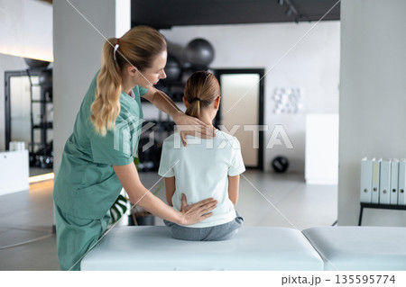 Therapist woman in medical uniform working with girl in rehab Therapist woman in medical uniform working with girl in rehab 135595774