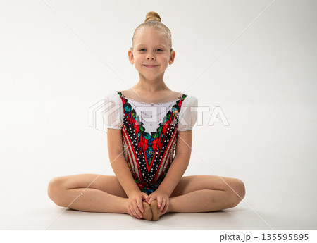 Portrait of gymnast with cochlear implant smiling in training leotard in studio. Hearing rehabilitation, self confidence and inclusive childhood identity through rhythmic gymnastics 135595895