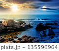 rocky shore of the sea coast under blue sky. day and night time change concept. beautiful view under sun and moon. resort scenery during vacation season in summer. harmony and progress calendar 135596964