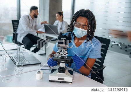 Process of using microscope. Doctors are in the clinic 135598416