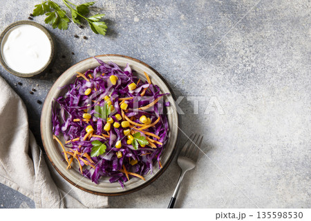 Healthy vibrant salad with red cabbage, corn, and carrots on rustic background Healthy vibrant salad with red cabbage, corn, and carrots on rustic background 135598530