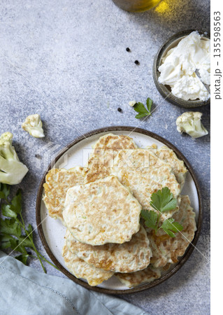 Homemade cauliflower pancakes with fresh herbs and cheese garnish Homemade cauliflower pancakes with fresh herbs and cheese garnish 135598563