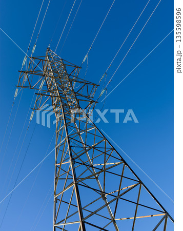 Steel electricity pylon structure against clear blue sky capturing power and energy 135598596