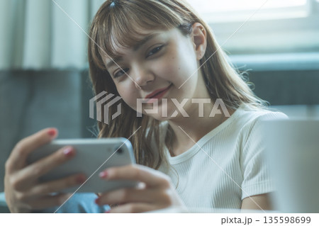 スマホでゲームを楽しむ女性 135598699