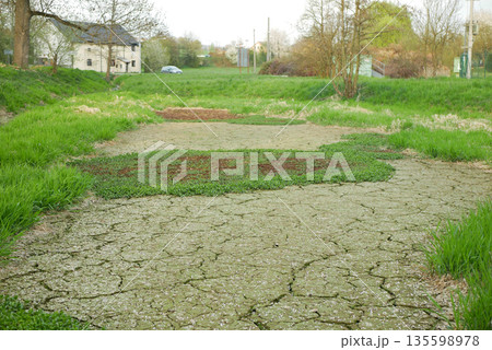 Drought cracked pond in village mud lake drying up and without water. Desiccation dried up soil mud crust and wild fire risk. Dry degradation due to climate change, ocean temperatures, changes in the Drought cracked pond in village mud lake drying up and without water. Desiccation dried up soil mud crust and wild fire risk. Dry degradation due to climate change, ocean temperatures, changes in the 135598978