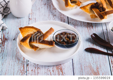 Beautiful toast with jam and a bowl of jam on a plate on the table 135599019