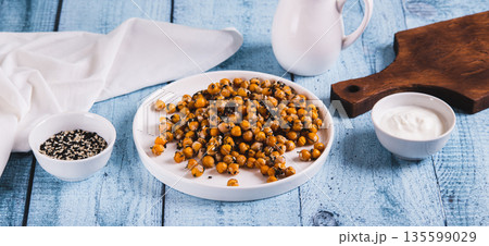 Delicious baked chickpeas with dill and sesame seeds on a plate on the table web banner Delicious baked chickpeas with dill and sesame seeds on a plate on the table web banner 135599029