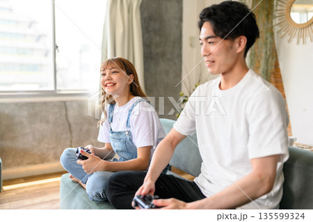 リビングでゲームを楽しむ二人 リビングでゲームを楽しむ二人 135599324