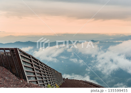 富士山七合目付近の登山道に設置された防護柵と眼下に広がる幻想的な雲海の展望 135599455