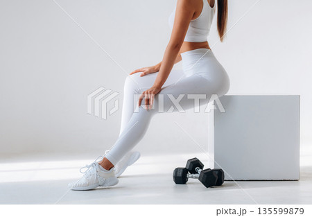 Dumbbells are on the floor. Close up view of sportive woman in the studio Dumbbells are on the floor. Close up view of sportive woman in the studio 135599879
