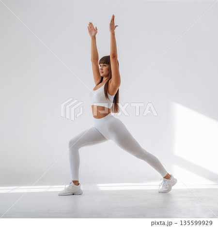 Warrior yoga asana. Young sportive woman is in the studio Warrior yoga asana. Young sportive woman is in the studio 135599929