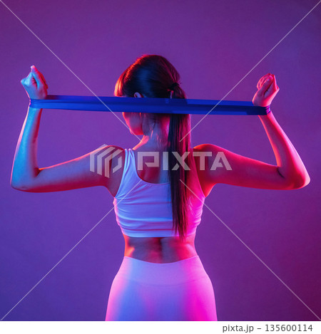 Stretching hands. Young sportive woman is in the studio 135600114