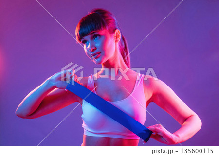 Stretching hands. Young sportive woman is in the studio 135600115