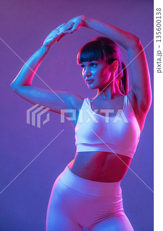 Athletic fitness body type, standing. Young sportive woman is in the studio Athletic fitness body type, standing. Young sportive woman is in the studio 135600138