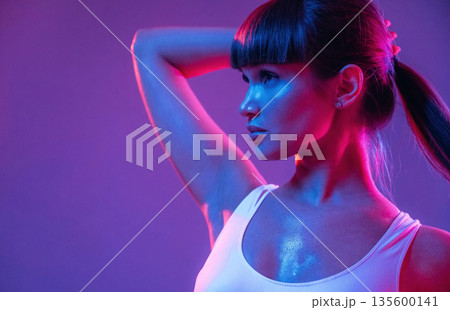 Touching her hair, standing and posing. Young sportive woman is in the studio Touching her hair, standing and posing. Young sportive woman is in the studio 135600141