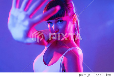 Palm of the hand in front of her. Young sportive woman is in the studio Palm of the hand in front of her. Young sportive woman is in the studio 135600166