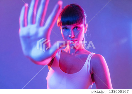 Palm of the hand in front of her. Young sportive woman is in the studio Palm of the hand in front of her. Young sportive woman is in the studio 135600167