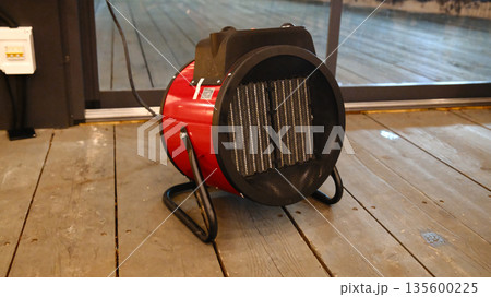 Portable electric space heater on wooden floor in modern interior Portable electric space heater on wooden floor in modern interior 135600225