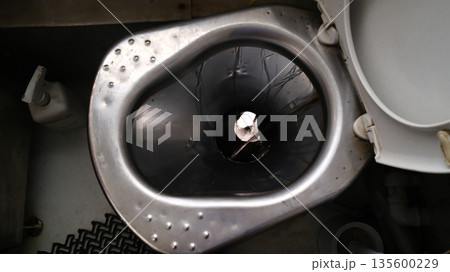 Stainless steel toilet bowl in small bathroom inside passenger train Stainless steel toilet bowl in small bathroom inside passenger train 135600229
