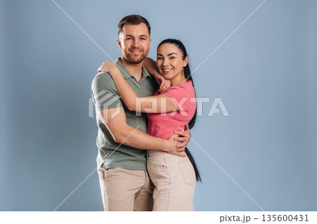 Embracing, standing and posing. Man and woman are in the studio Embracing, standing and posing. Man and woman are in the studio 135600431