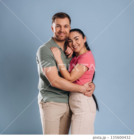Embracing, standing and posing. Man and woman are in the studio 135600432