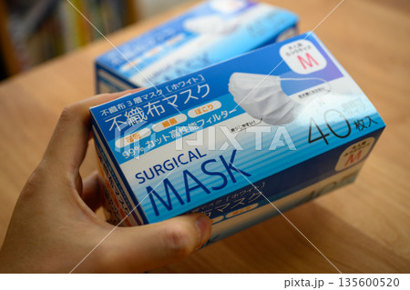 サージカルマスク箱を持つ手 サージカルマスク箱を持つ手 135600520