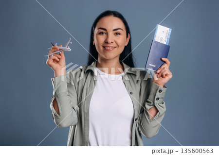 Model of plane, travel conception. Beautiful woman is against background 135600563