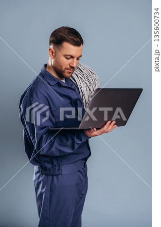 Laptop and internet cables, worker. Handsome man is against background 135600734