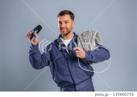 Worker is ready to install the internet connection. Handsome man is against background Worker is ready to install the internet connection. Handsome man is against background 135600739