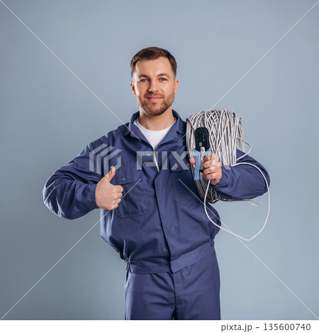 Worker is ready to install the internet connection. Handsome man is against background 135600740