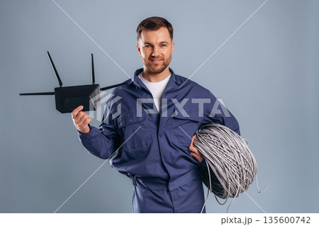 Worker is ready to install the internet connection. Handsome man is against background 135600742