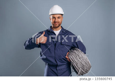 Showing thumb up, internet cables. Handsome man is against background 135600745
