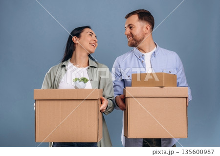 Couple is ready to move, with boxes. Man and woman are in the studio Couple is ready to move, with boxes. Man and woman are in the studio 135600987