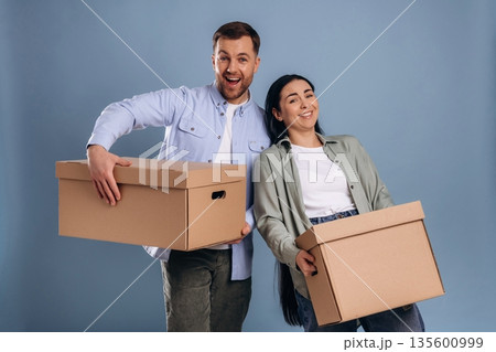 Together with boxes, moving. Man and woman are in the studio 135600999