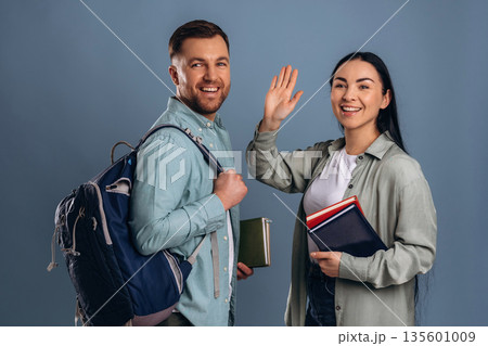 Backpack and boxes, students. Man and woman are in the studio 135601009