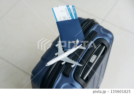 Top view of suitcase, plane toy, passport and tickets, tourism conception Top view of suitcase, plane toy, passport and tickets, tourism conception 135601825