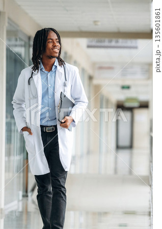 Walking forward. Young male black doctor is in the corridor 135601861