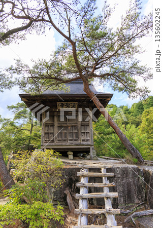 長野県寝覚めの床の岩の上に建つ木造のお堂と初秋の自然風景 135602245