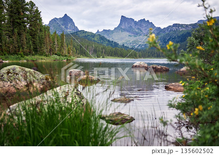 Scenic mountain lake with calm water and rocky shore. Natural landscape Scenic mountain lake with calm water and rocky shore. Natural landscape 135602502