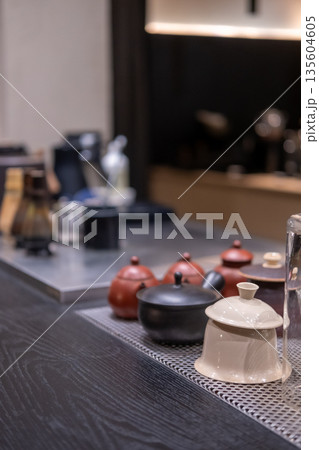 Traditional Japanese tea preparation tools on the counter, including tea cups and bamboo matcha whisks 135604605