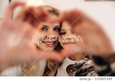 Hands with love gesture. Mother and daughter are together in domestic room Hands with love gesture. Mother and daughter are together in domestic room 135605384