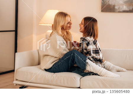 Good relationships, cozy. Mother and daughter are together in domestic room Good relationships, cozy. Mother and daughter are together in domestic room 135605480