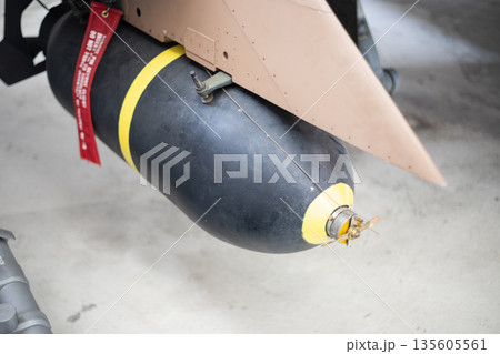 Jet fighter carrying bomb with remove before flight tag Jet fighter carrying bomb with remove before flight tag 135605561