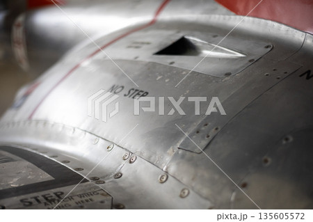 Aircraft metal skin showing warning message and rivets 135605572