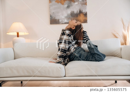 Fun on the sofa. Cute little girl is in the domestic room alone Fun on the sofa. Cute little girl is in the domestic room alone 135605575